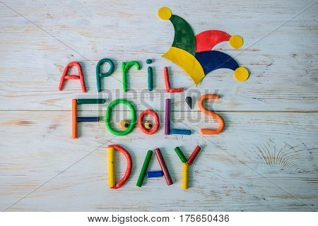 April Fools' Day text made with plasticine on white wooden background