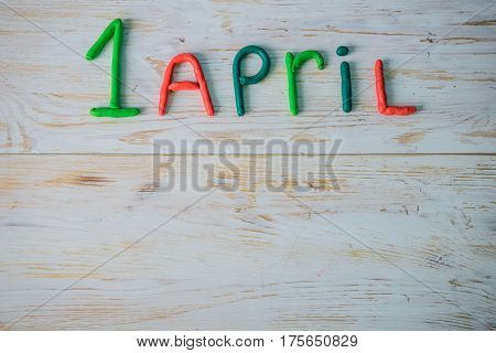 April Fools' Day text made with plasticine on white wooden background