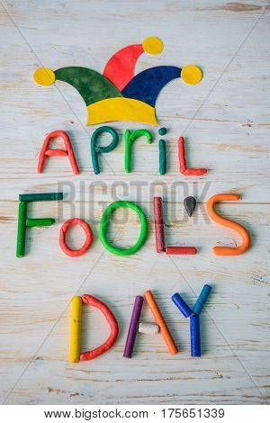 April Fools' Day text made with plasticine on white wooden background