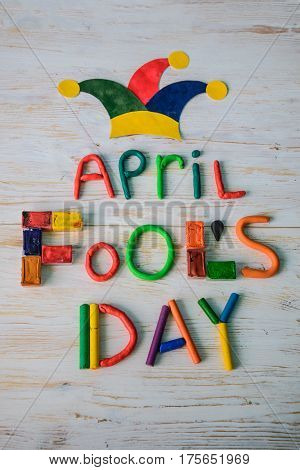April Fools' Day text made with plasticine on white wooden background