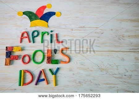 April Fools' Day text made with plasticine on white wooden background