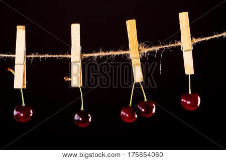 Red Cherry and rope on black with clamp fruit concept - desert, food