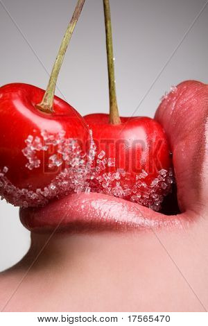 mladá žena ústa s červených třešní pokryté cukru