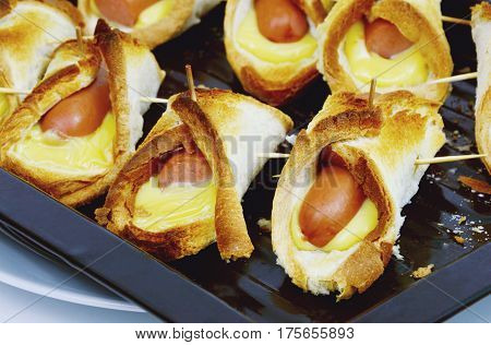 Toasted Hot Dogs and Cheese on black Oven tray