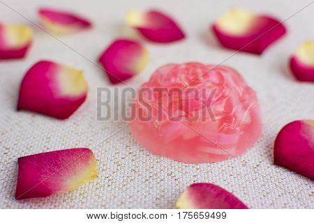 Organic homemade rose soap. Delicate rose petals on the background.