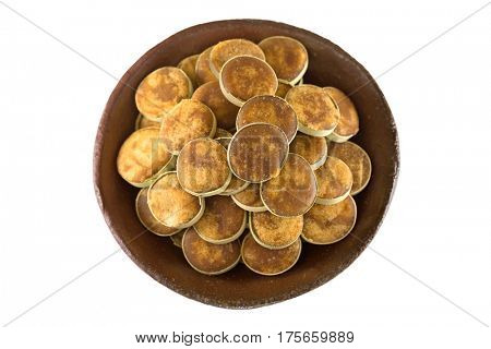 Clay bowl full of Jaggery sugar made of Asian Palmyra Palm sap filled in slices of small dried palm leaves, isolated on white background