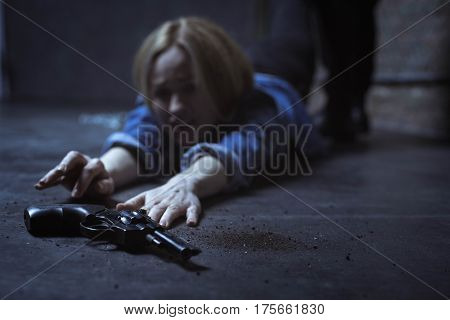 I can take it. Trapped powerless blonde woman trying reaching a gun for protecting herself while her captor dragging her pulling her away