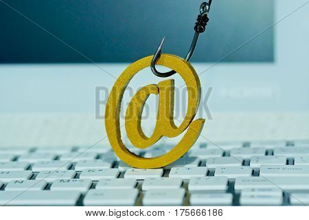 Email sign with a fish hook on computer keyboard. Email security and countermeasure concept