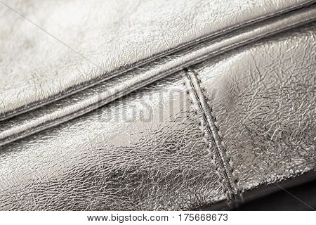 Close-up texture of evening silver handbag, clutch from genuine leather. For background, backdrop, substrate, use of composition. Concept of shopping, manufacturing, lifestyle, holiday, weekend