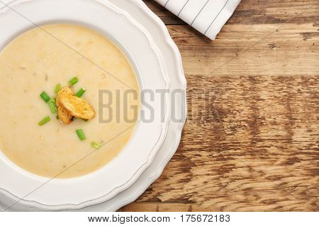 Delicious beer cheese soup with croutons on table