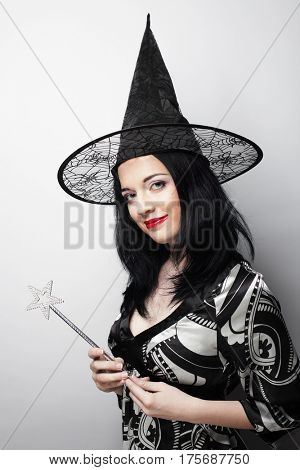 Funny Witch. Young happy woman with canival hat. Studio shot.