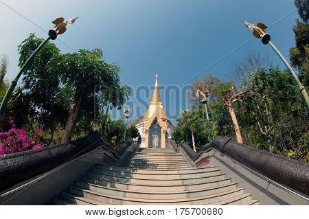 UDON THANI,THAILAND - JAN 25,2014:The Chedi Prathom Rattanamahaburaphachan above the steep staircase.The Chedi in Sri Lanka style, richly adorned with small golden mosaic stones,marble and granite ,in Wat Pa Phu Kon of Ban Na Kham,Na yung District in Udon