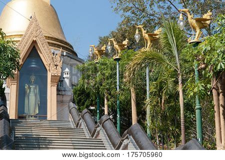 UDON THANI,THAILAND - JAN 25,2014:The Chedi Prathom Rattanamahaburaphachan above the steep staircase.The Chedi in Sri Lanka style, richly adorned with small golden mosaic stones,marble and granite ,in Wat Pa Phu Kon of Ban Na Kham,Na yung District in Udon
