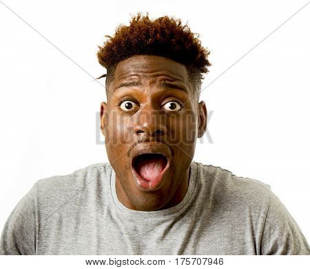 close up portrait of young attractive afro american man surprised with opened mouth and wide open eyes in disbelief amazed wow face expression isolated on white background
