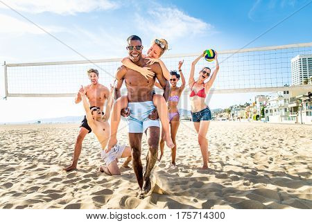 Group of friends playing beach volley - Multi-ethic group of people having fun on the beach