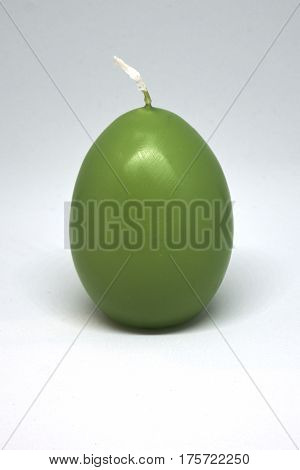 Easter candle in egg form on a white background isolated