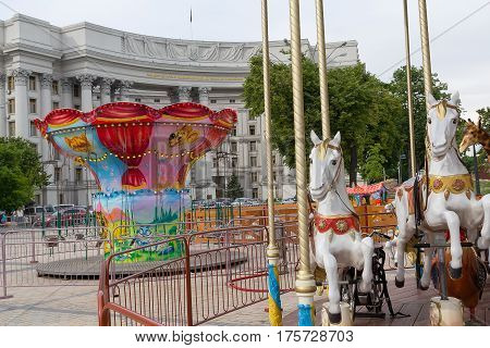 Kiev Ukraine - May 11 2016: Carousels on the Mikhaylovskaya Square against the backdrop of the Ministry of Foreign Affairs