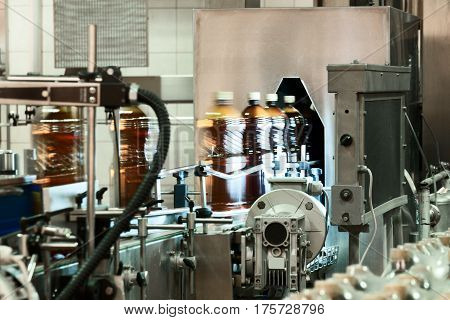 Plastic bottles filled with beer on the conveyor of the filling machine. Phase control on the absence of extraneous inclusions.