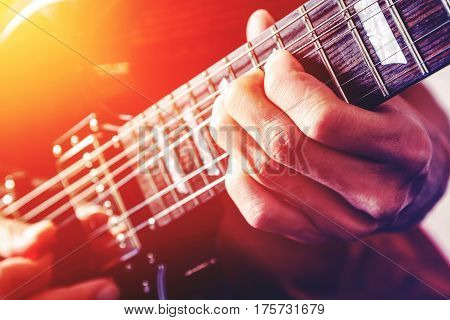 Close up shot of the man playing electric guitar