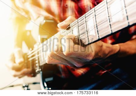 Close up shot of the man playing electric guitar