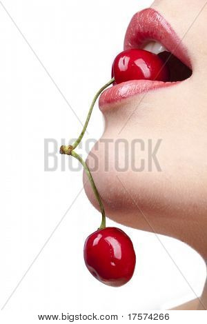 Mladá žena ústa s červenými třešně nad bílým pozadím