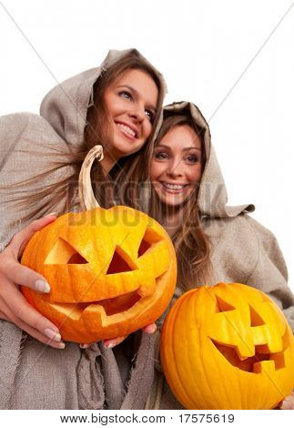Dvě jeptišky usmívající se v držení halloween dýně nad bílé kleriky