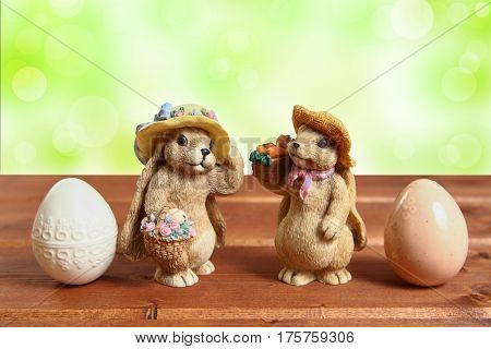 Two Easter bunny on wood background with decorative eggs