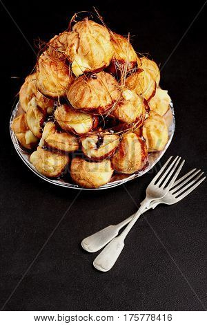 Cake Profiteroles With Caramel On Black Background.selective Focus