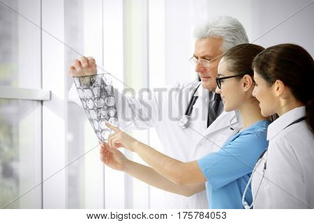 Group of doctors looking at roentgenogram in clinic
