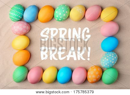 Spring break concept. Colorful Easter eggs on sand