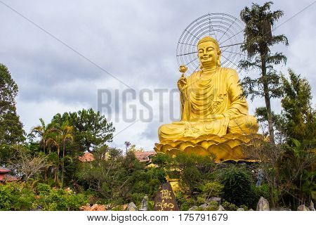 Statue of Big Golden Sitting Buddha in Van Hanh pagoda monastery in Dalat, Vietnam
