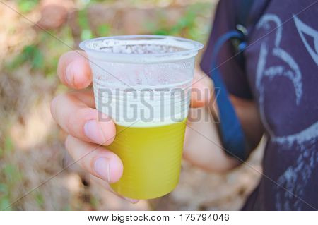 A glass of freshly squeezed reed juice in the hands of men. Rushy juice is one of popular drink in Indian cuisine. Healthy and proper food