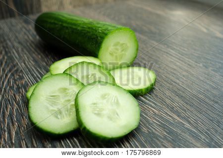 Heap of fresh sliced Cucumbers on an wooden table.