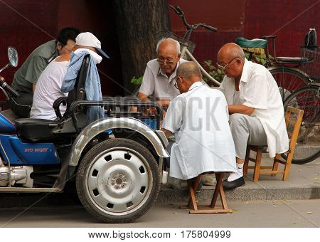 Beijing, China - Jul 5, 2011: Chinese Men Playing Mahjong (or Majiang, Very Popular Chinese Game) In