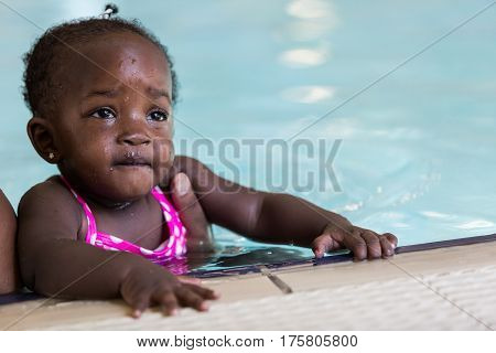 Infant swimming lessons in indoor pool .