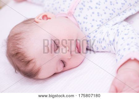 Cute baby girl sleeping in her crib.