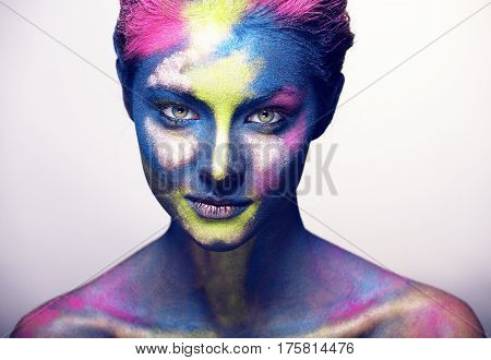 beauty woman with creative make up like Holy celebration in India closeup, colored print on face