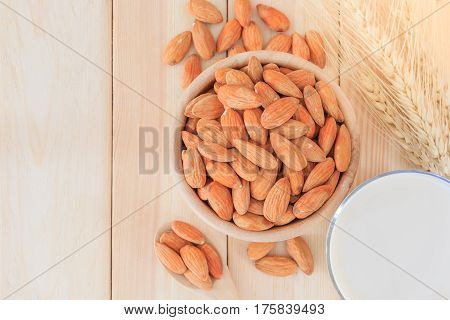 Almond milk in glass with almonds on wooden table Top view with copy space and text.