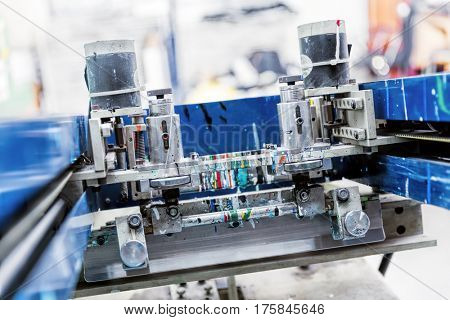 Print screening metal machine. Industrial printer. Serigraphy workshop.