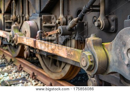 Weathered drive mechanism of an old  diesel-electric locomotive parked on rusty rails in the Netherlands.