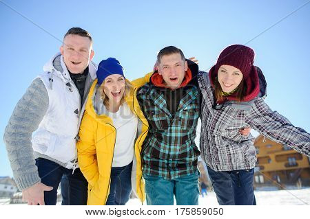 Cheerful group of friends posing for the camera. Two young men and two girl. All good mood. Friends are hugging and laughing merrily.