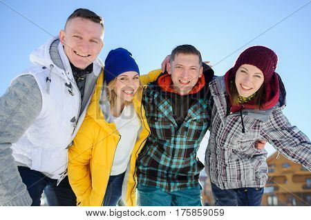 Cheerful group of friends posing for the camera. Two young men and two girl. All good mood. Friends are hugging and laughing merrily.
