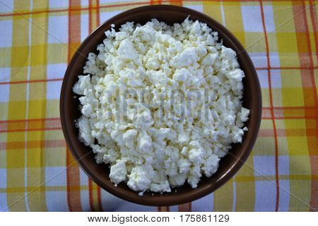 Cottage cheese in a brown bowl with oatmeal and jam