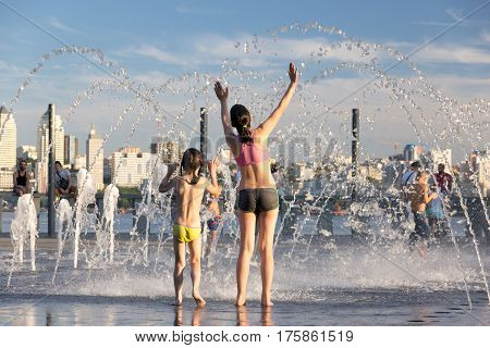 People fleeing from the heat in a city fountain in the centre of a European city during extremely hot summer day when temperature reached plus 38 degrees Celsius. July 2, 2016, Dnipro, Ukraine