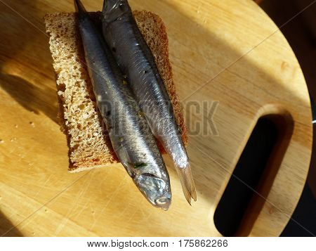 A bread, spicy salting anchovy  and a glass of vodka. Closeup. Gorgeous home appetizer under a glass of vodka. Natural food. Traditional Dishes of Russian Cuisine.