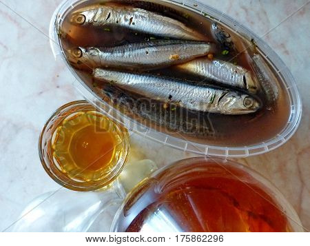 A glass of vodka and bank with spicy salting anchovys. Vodka honey with pepper (Home tincture fortress 45 degrees). Decanter with vodka (tincture). Closeup. Natural food. Traditional Russian cuisine.