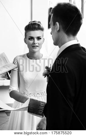 Happy Stylish Bride And Elegant Groom Exchanging Vows At Catholic Wedding Ceremony At Church