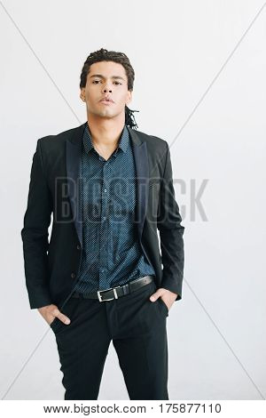 Happy young businessman in black suite and blue shirt standing over white background. Portrait of a handsome  boy. Color