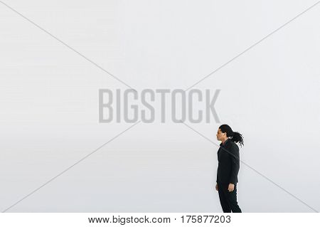 Happy young businessman in black suite and blue shirt standing over white background. Portrait of a handsome  boy. Color