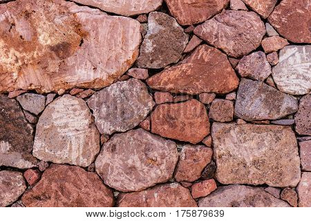 Red natural stone wall background, stone texture